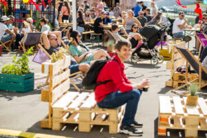 Zdjęcie z festiwalu, uczestnicy festiwalu siedzą na leżakach w strefie chill out